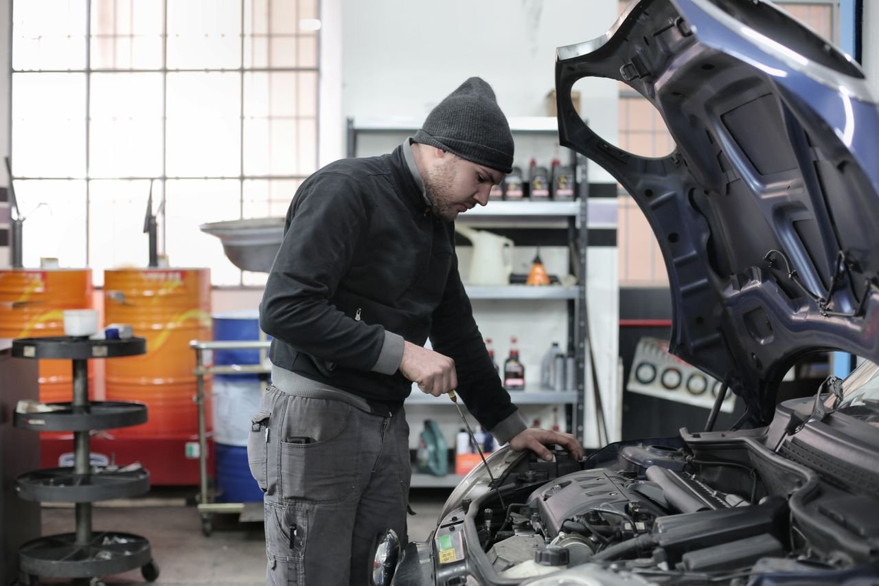 Crafting Captivating Headlines: Your awesome post title goes here Mechanic checking a car engine in a garage, ensuring quality maintenance and repair.